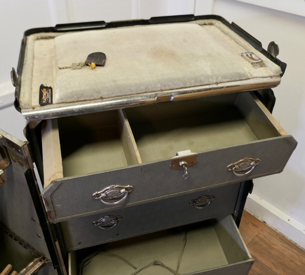 An open Art Deco Hartmann fitted steamer trunk featuring a section with wooden clothes hangers and a section with five pull-out drawers. View XI