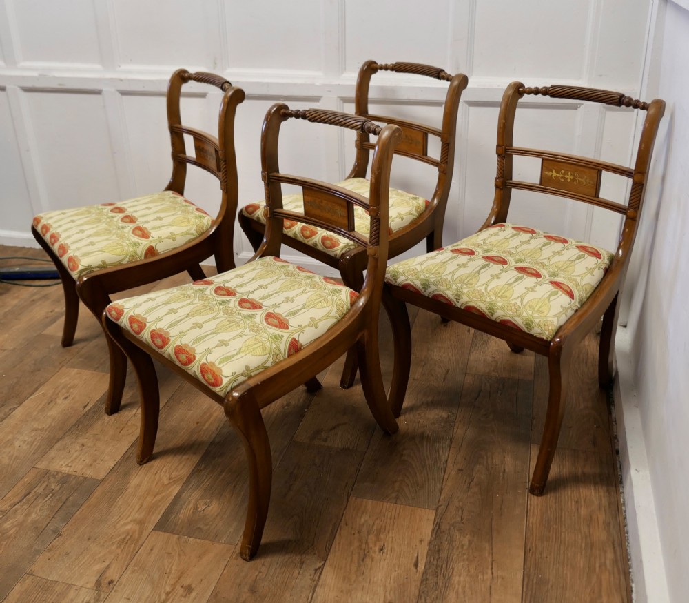 A set of four Art Nouveau walnut dining chairs featuring twisted top rails, inlaid back splats, and floral patterned fabric seats. View II