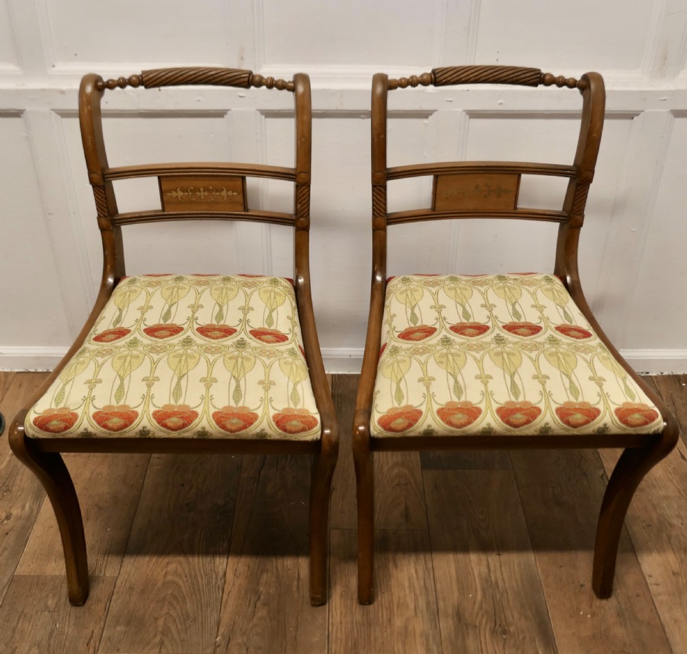 A set of four Art Nouveau walnut dining chairs featuring twisted top rails, inlaid back splats, and floral patterned fabric seats. View III