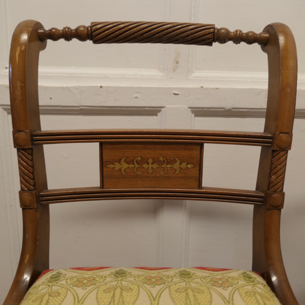 A set of four Art Nouveau walnut dining chairs featuring twisted top rails, inlaid back splats, and floral patterned fabric seats. View V