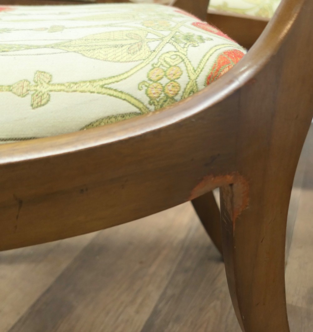 A set of four Art Nouveau walnut dining chairs featuring twisted top rails, inlaid back splats, and floral patterned fabric seats. View VII