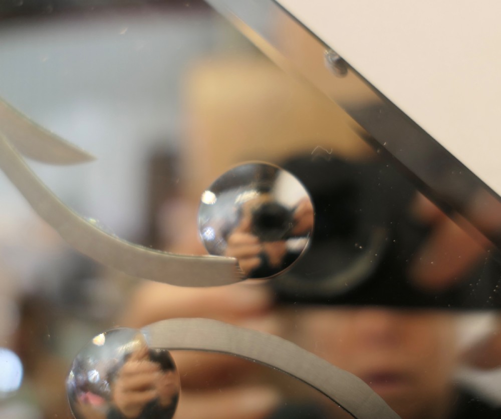A diamond-shaped Art Deco wall mirror featuring a clear main glass panel with etched scroll motifs and angled peach-tinted glass lower borders. View VII