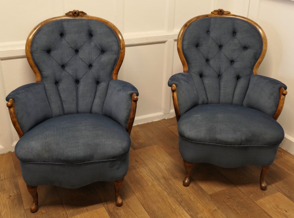 A pair of French salon armchairs upholstered in blue button-backed velvet with carved walnut frames and short wooden legs. View IV