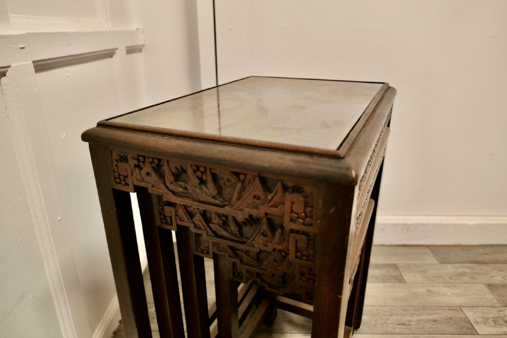 A set of four dark brown hardwood nesting tables featuring carved pierced aprons and glass-inset tops. View XIV
