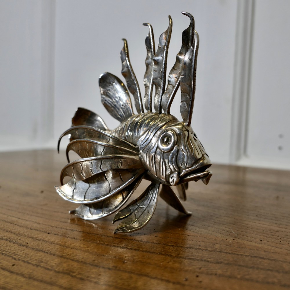 A sterling silver lionfish model featuring dramatic fan-like dorsal spines and engraved scales displayed on a wooden surface. View II