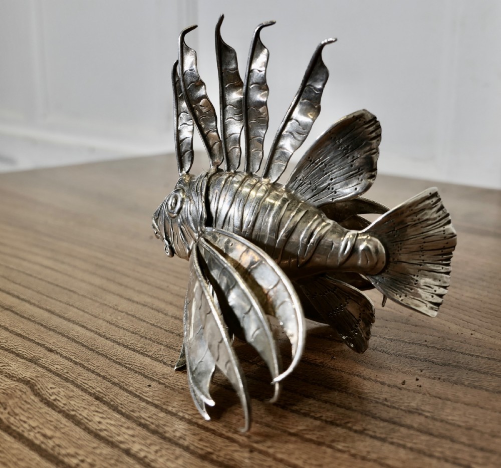 A sterling silver lionfish model featuring dramatic fan-like dorsal spines and engraved scales displayed on a wooden surface. View VI