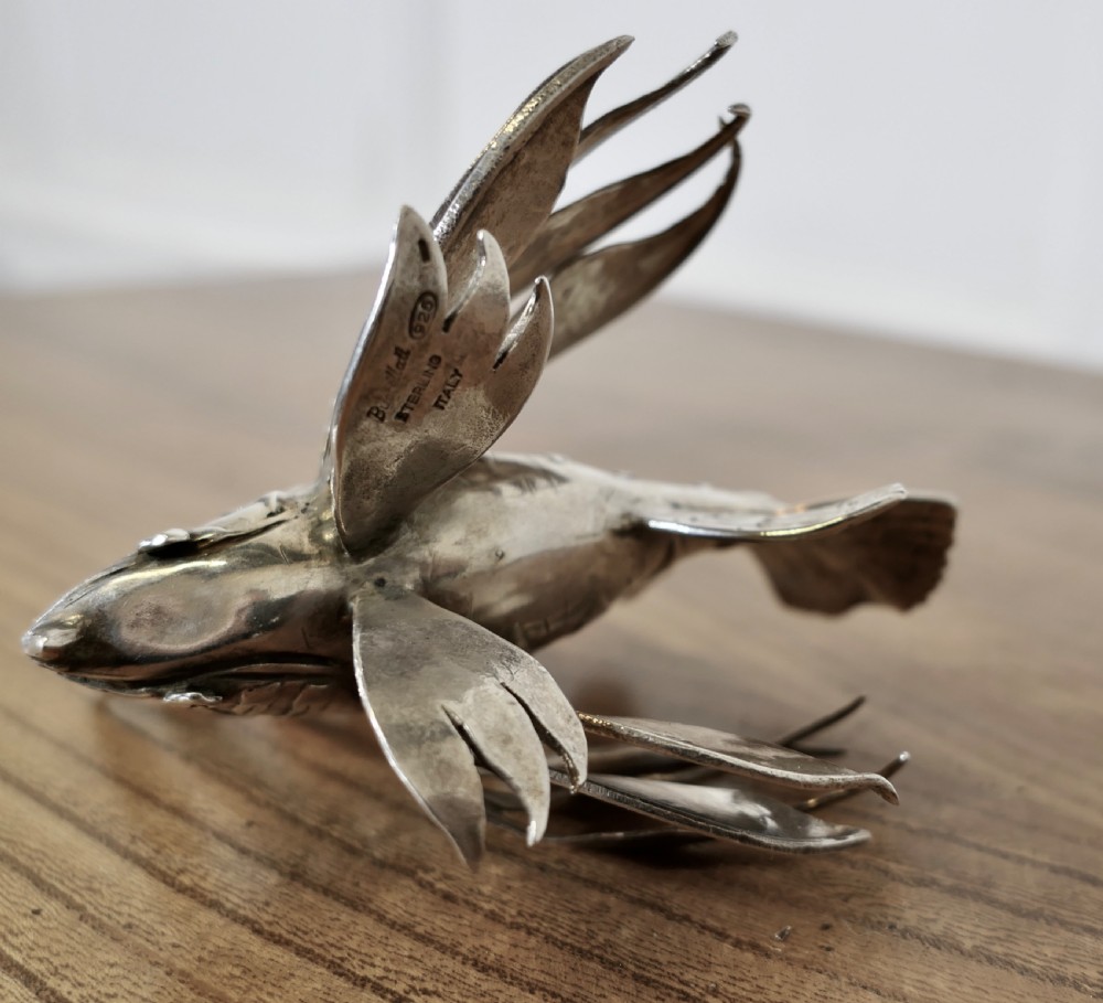 A sterling silver lionfish model featuring dramatic fan-like dorsal spines and engraved scales displayed on a wooden surface. View VII