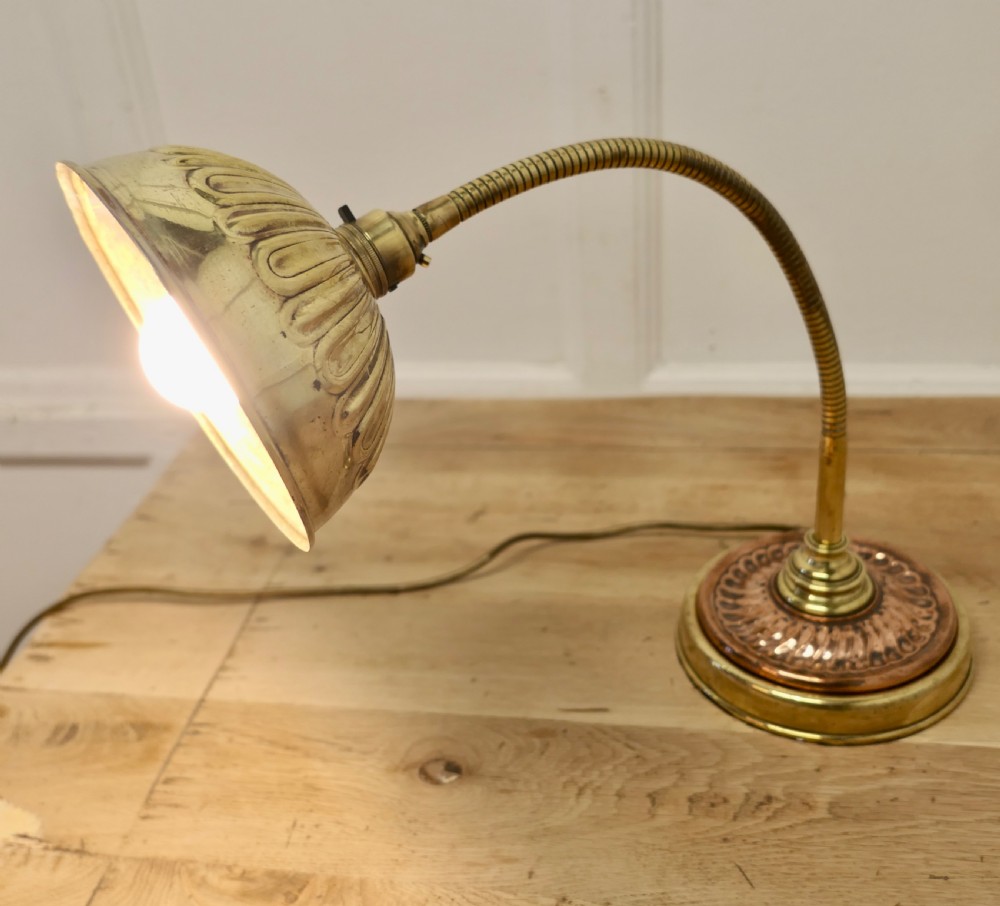 An Art Deco desk lamp featuring a flexible gooseneck arm, a ribbed brass shade, and a circular copper and brass base. View IV