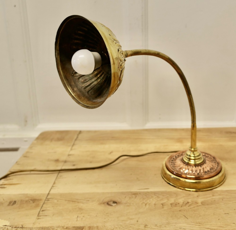An Art Deco desk lamp featuring a flexible gooseneck arm, a ribbed brass shade, and a circular copper and brass base. View VI