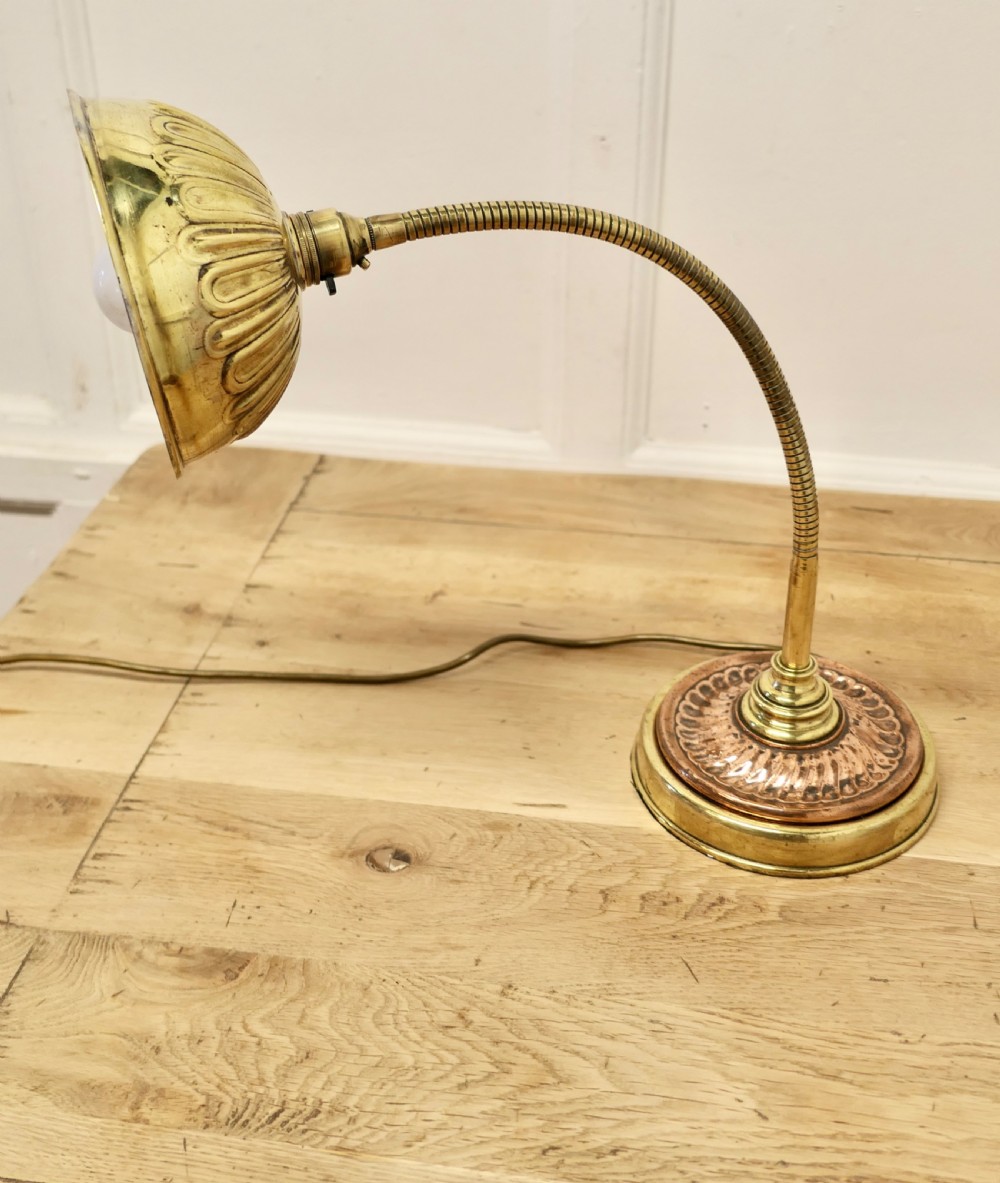 An Art Deco desk lamp featuring a flexible gooseneck arm, a ribbed brass shade, and a circular copper and brass base. View VII