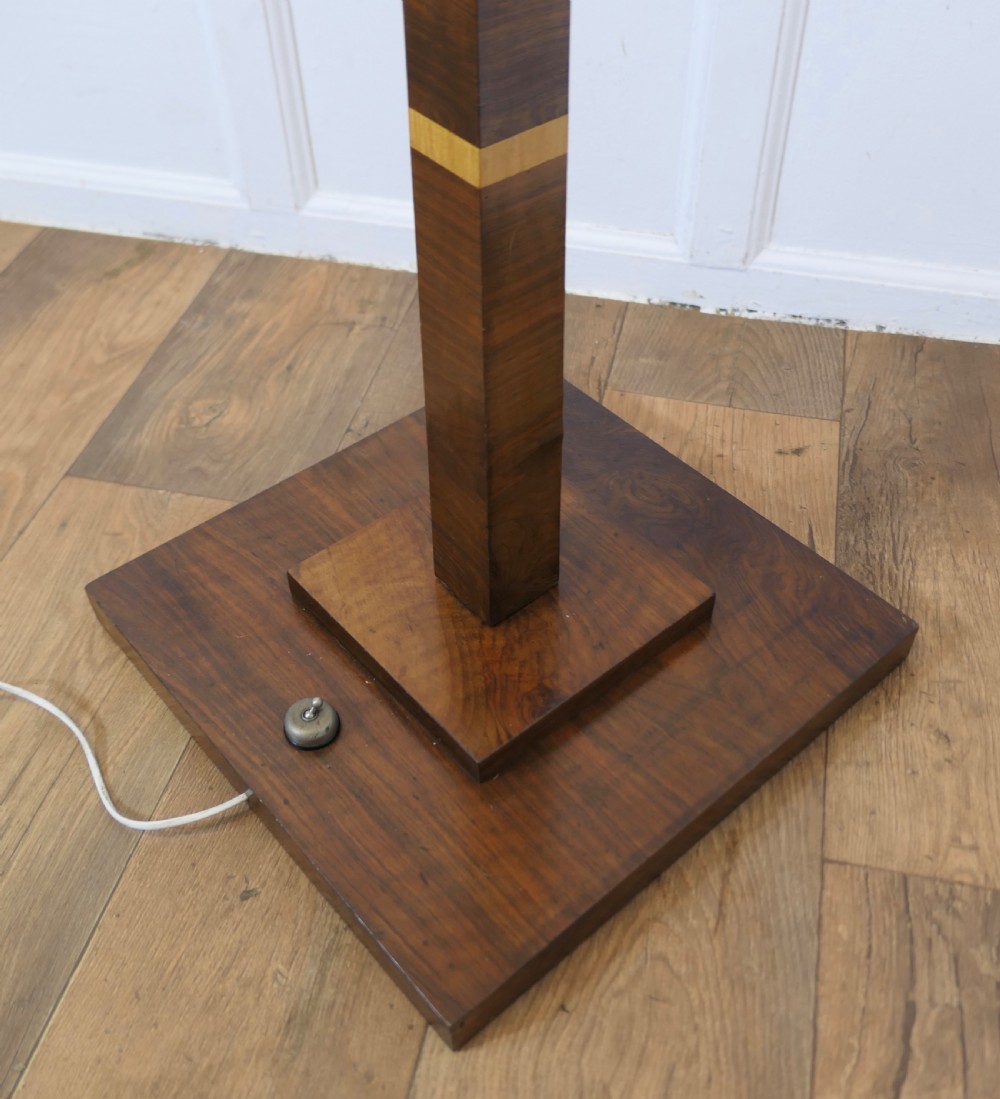 An Art Deco walnut floor lamp featuring a tapered rectangular stem with inlaid banding, a stepped square base, and a fabric lampshade. View V
