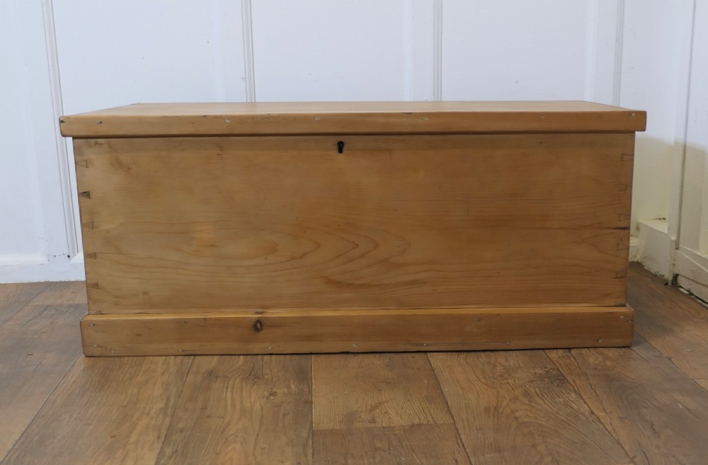 A rectangular Victorian pine blanket box featuring hand-cut dovetail corner joints, a flat lid, and a central keyhole escutcheon.