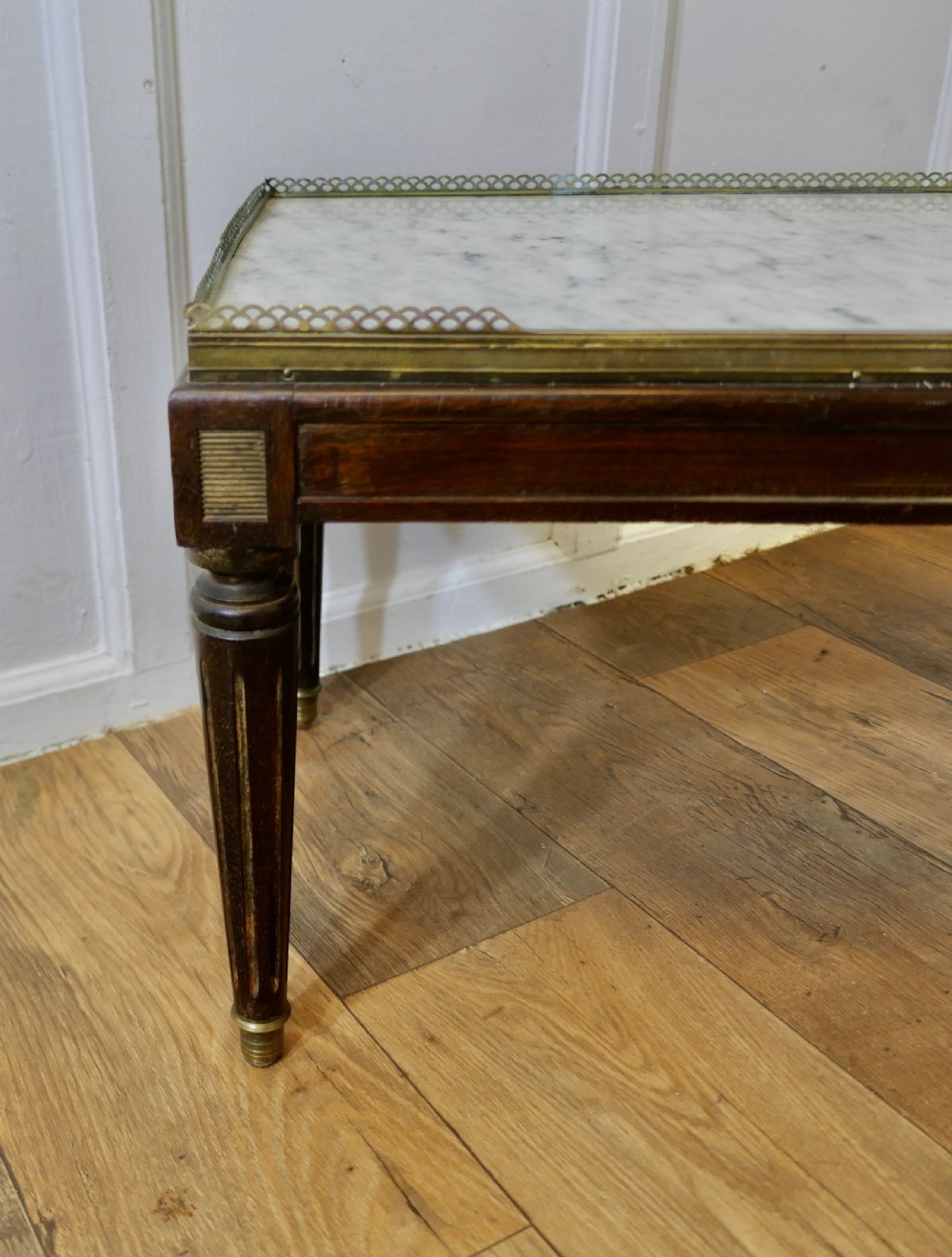 A French nineteenth-century rectangular dark wood low table with fluted tapered legs, brass feet, and a pierced brass gallery around the top edge. View V