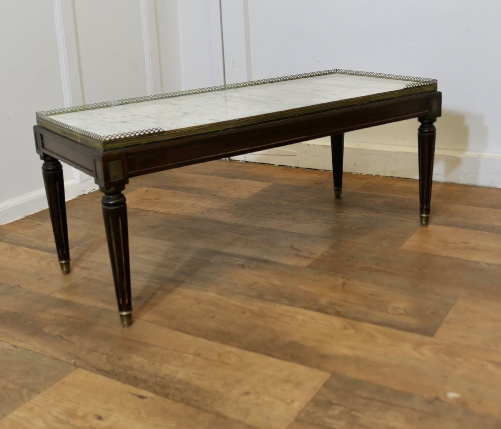 A French nineteenth-century rectangular dark wood low table with fluted tapered legs, brass feet, and a pierced brass gallery around the top edge. View VIII