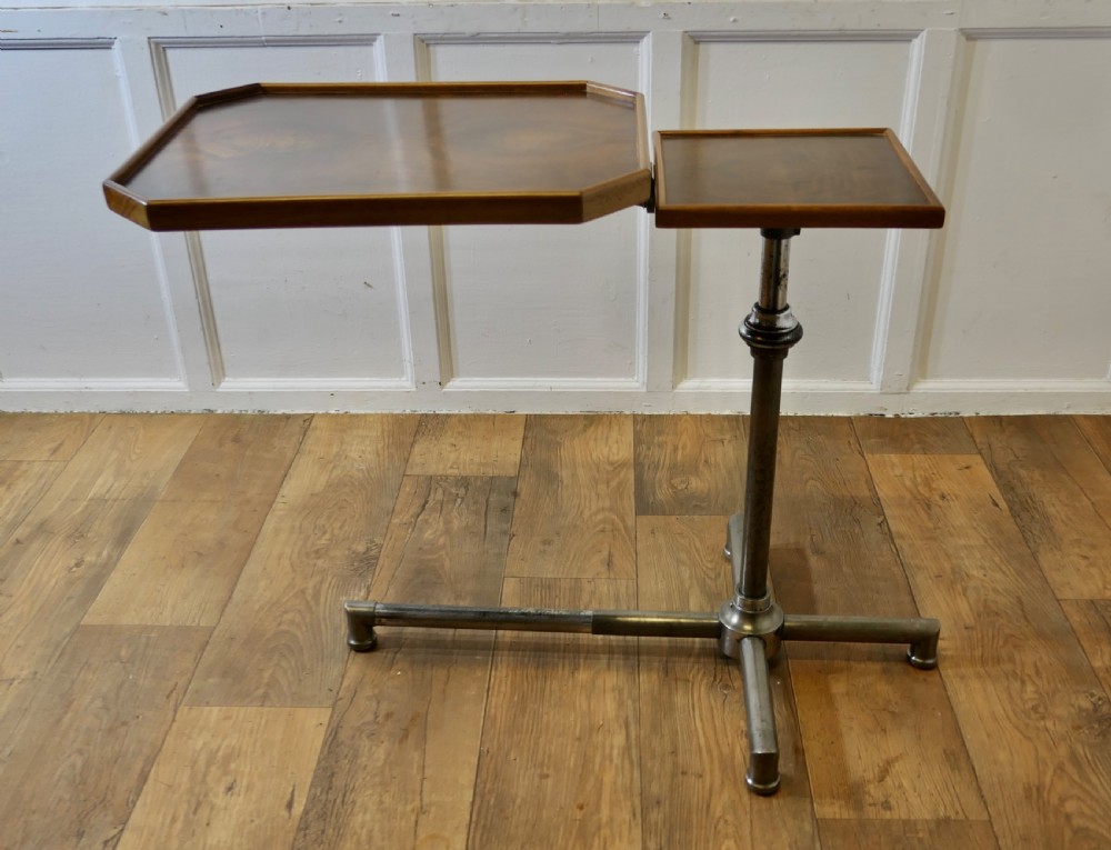 An Art Deco adjustable reading stand featuring two walnut wooden tray tops on a tubular chrome column and cross-form base.