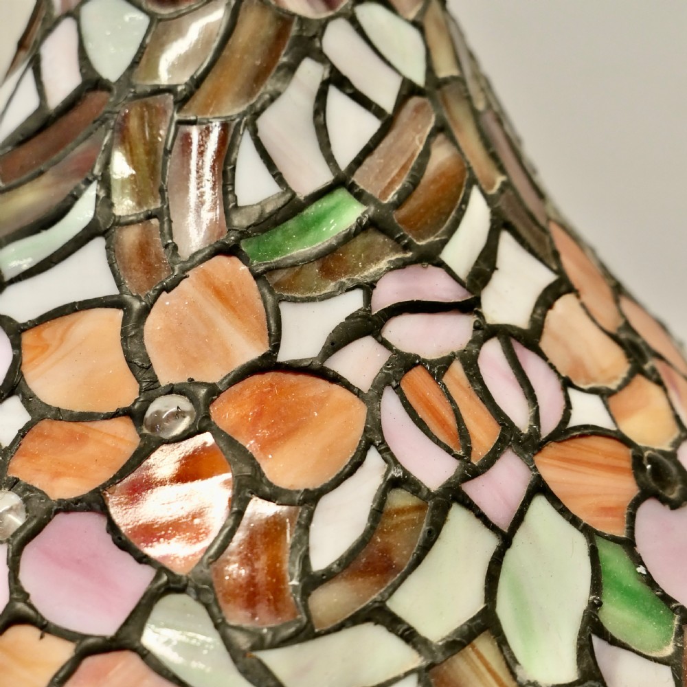 A conical Arts and Crafts stained glass lampshade featuring an amber and cream floral pattern with a scalloped lower edge and brass ceiling fittings. View VI