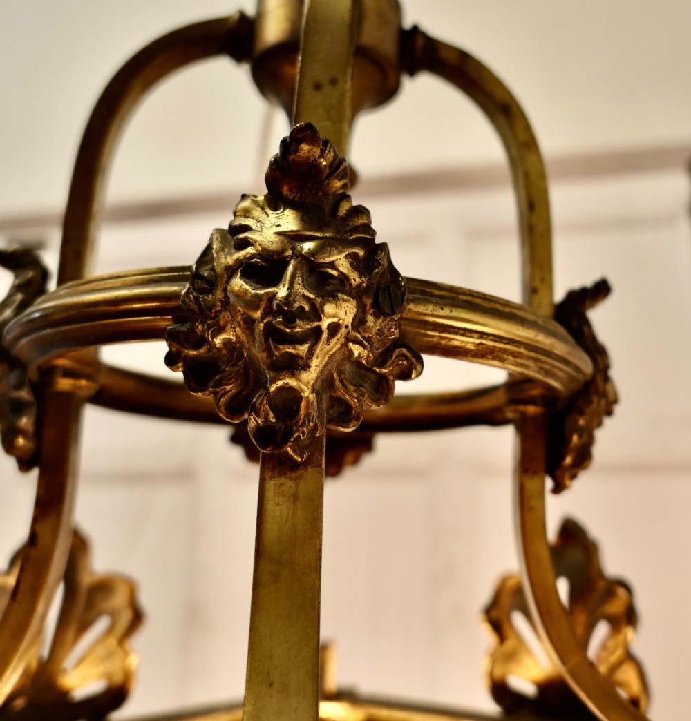 A tapered hexagonal gilt brass hall lantern featuring starburst-etched glass panels, acanthus leaf finials, and side-mounted light fittings. View X
