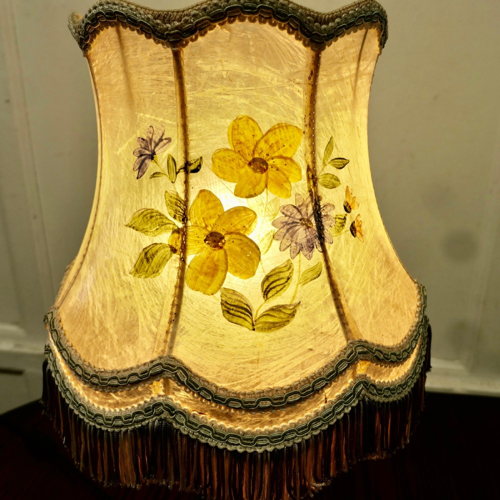 A turned dark wood and pewter table lamp featuring a scalloped cream fabric shade decorated with hand-painted yellow and purple flowers and finished with tassel fringe. View VI