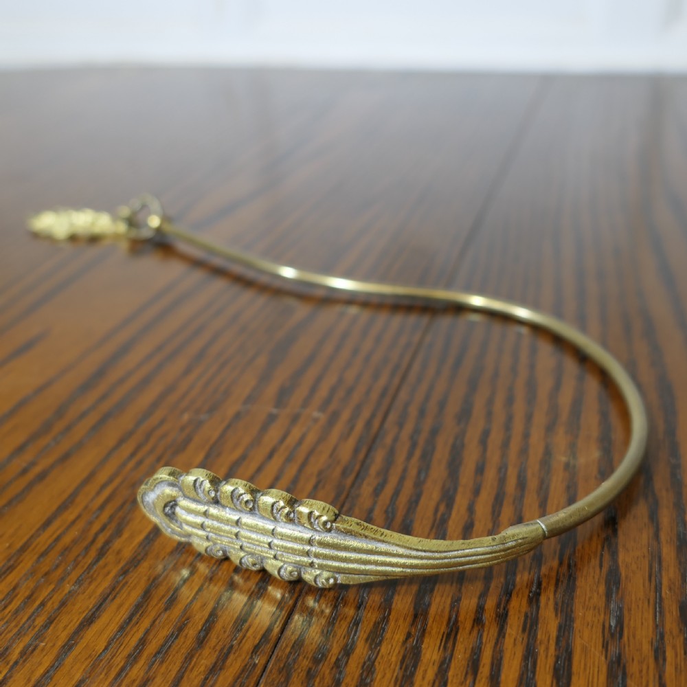A pair of large 19th-century French brass curtain tiebacks featuring curved arms with decorative terminal plates. View IV