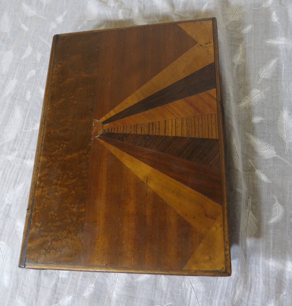An Art Deco book-shaped wooden secret safe featuring a geometric sunburst parquetry design crafted from contrasting timber veneers. View III