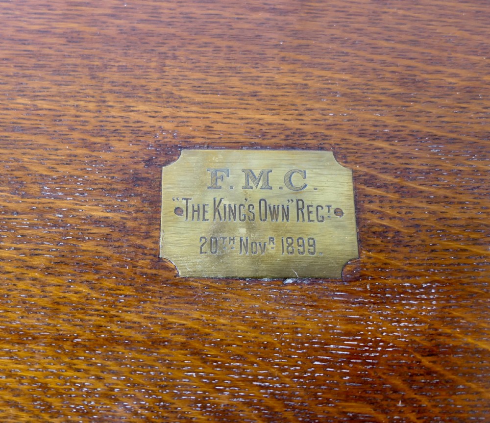 A rectangular dark oak presentation box featuring a keyhole on the front panel and an engraved brass plaque on the top lid. View II