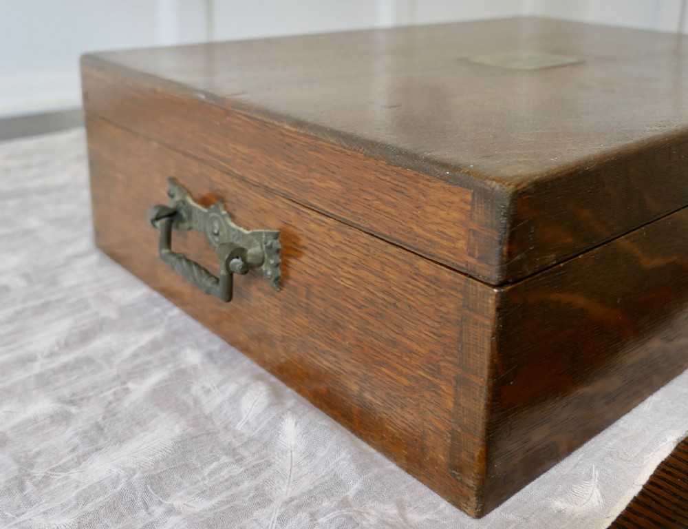 A rectangular dark oak presentation box featuring a keyhole on the front panel and an engraved brass plaque on the top lid. View IV