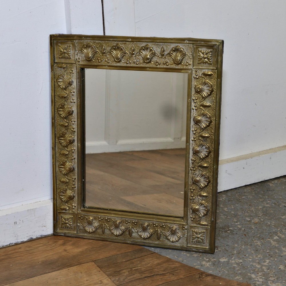 A rectangular wall mirror featuring an embossed brass frame decorated with shell motifs and stippled texture. View II