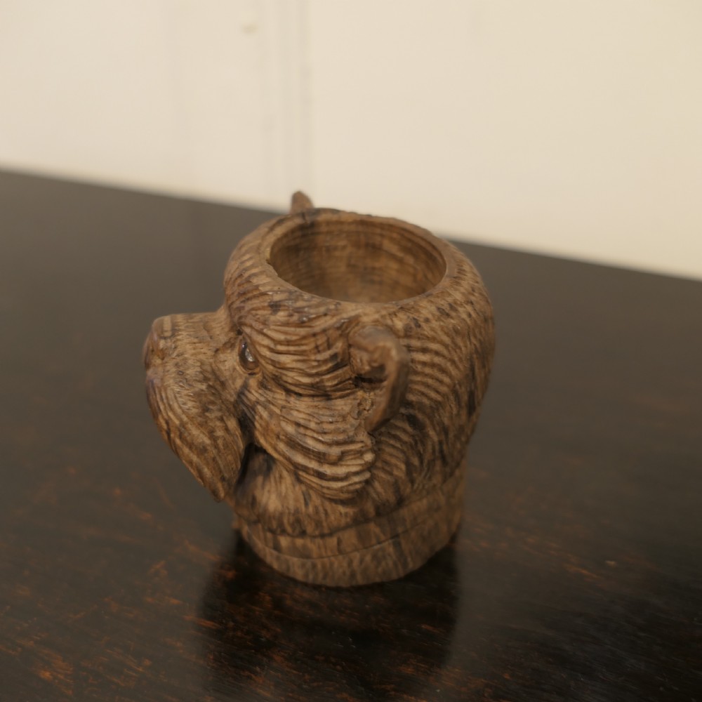 A hand-carved wooden head of a Scottish terrier with glass eyes and carved fur details. View IV