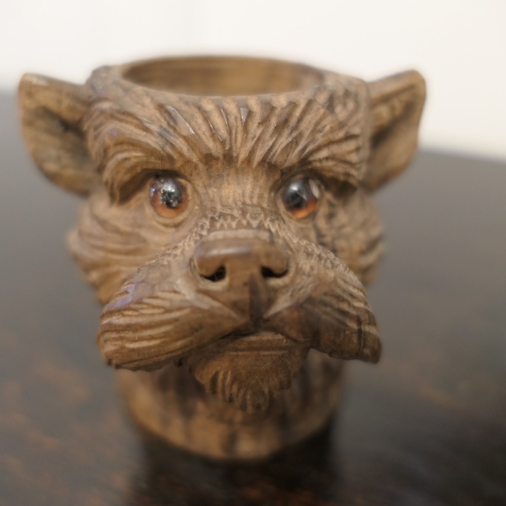 A hand-carved wooden head of a Scottish terrier with glass eyes and carved fur details. View VI