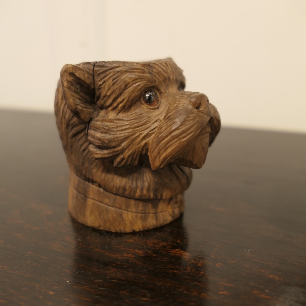 A hand-carved wooden head of a Scottish terrier with glass eyes and carved fur details. View VII
