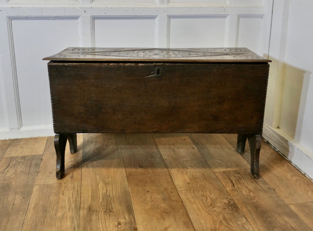 A dark oak plank coffer featuring a geometric carved pattern on the top lid, slab ends, and a central keyhole.