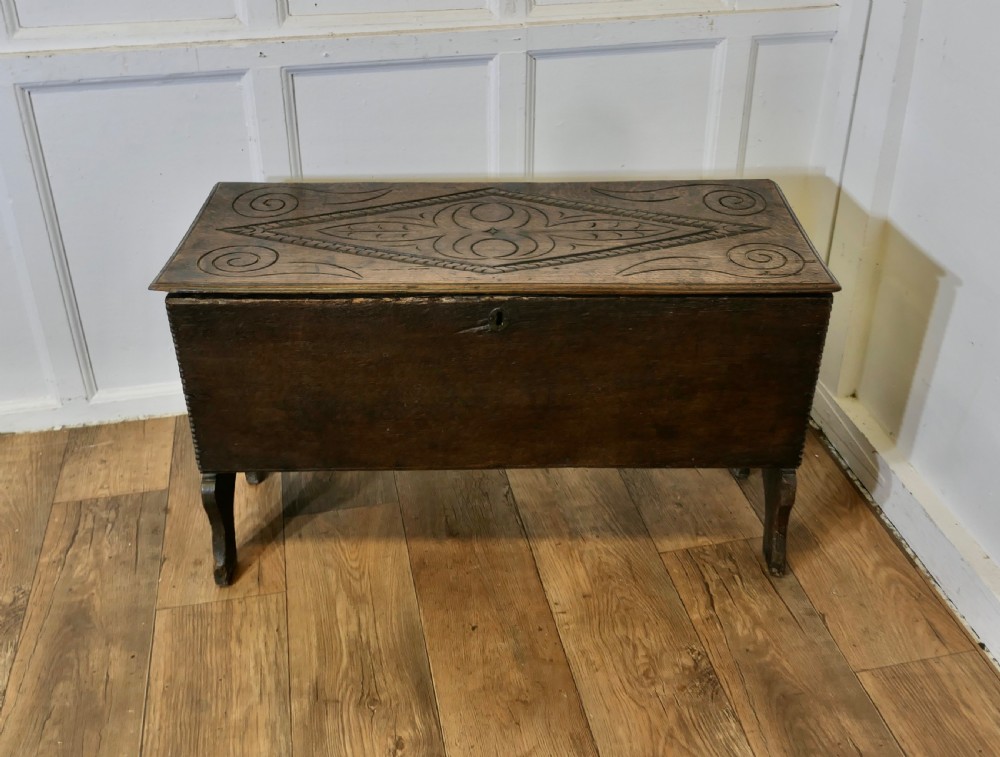 A dark oak plank coffer featuring a geometric carved pattern on the top lid, slab ends, and a central keyhole. View II