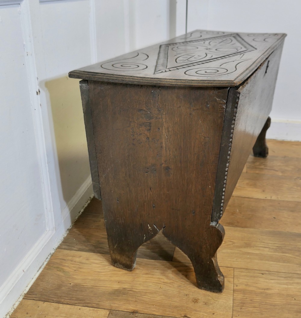 A dark oak plank coffer featuring a geometric carved pattern on the top lid, slab ends, and a central keyhole. View III