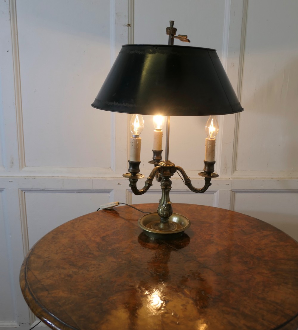A French triple-light bouillotte lamp featuring a dark green painted toleware shade, three brass candle arms, and a dished brass tray base. View II