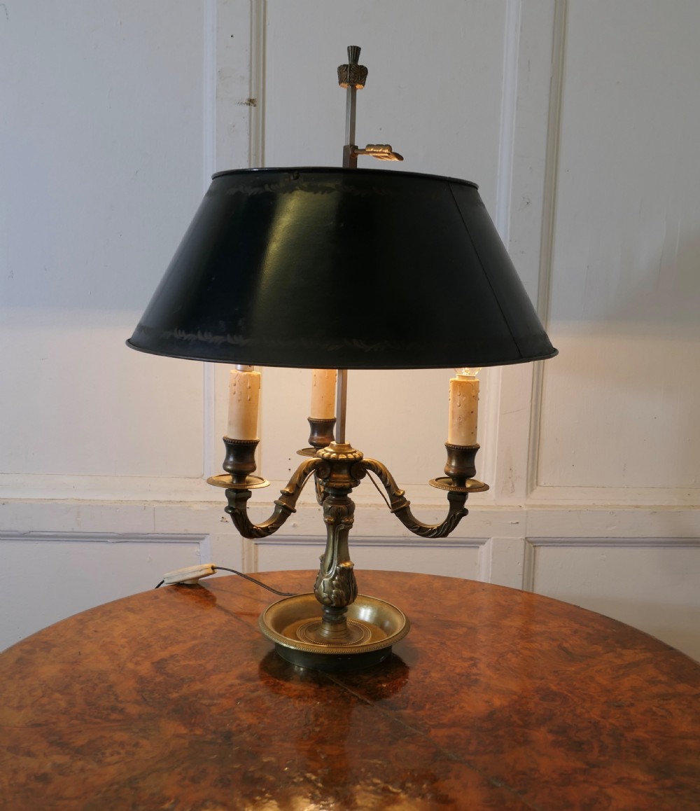 A French triple-light bouillotte lamp featuring a dark green painted toleware shade, three brass candle arms, and a dished brass tray base. View III