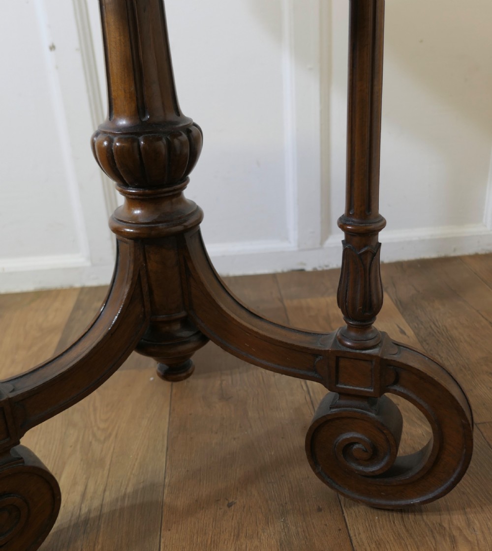 A nineteenth-century burr walnut wine table featuring a circular top supported by turned pillars and carved scroll feet. View VIII