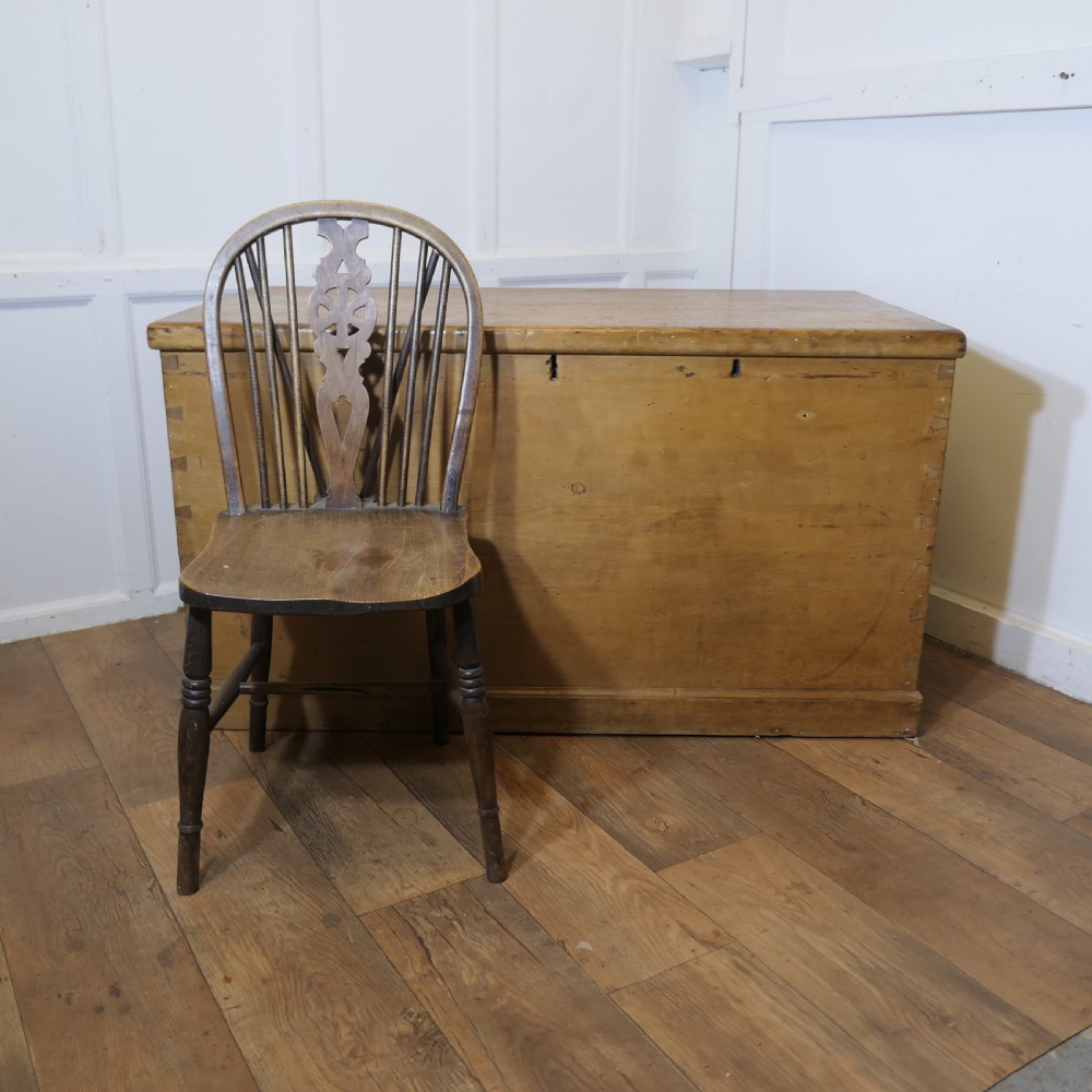 A large rectangular Victorian polished pine blanket box with visible dovetail joints, a flat hinged lid, and a thick wooden plinth base. View III