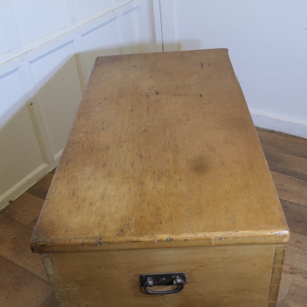 A large rectangular Victorian polished pine blanket box with visible dovetail joints, a flat hinged lid, and a thick wooden plinth base. View IX
