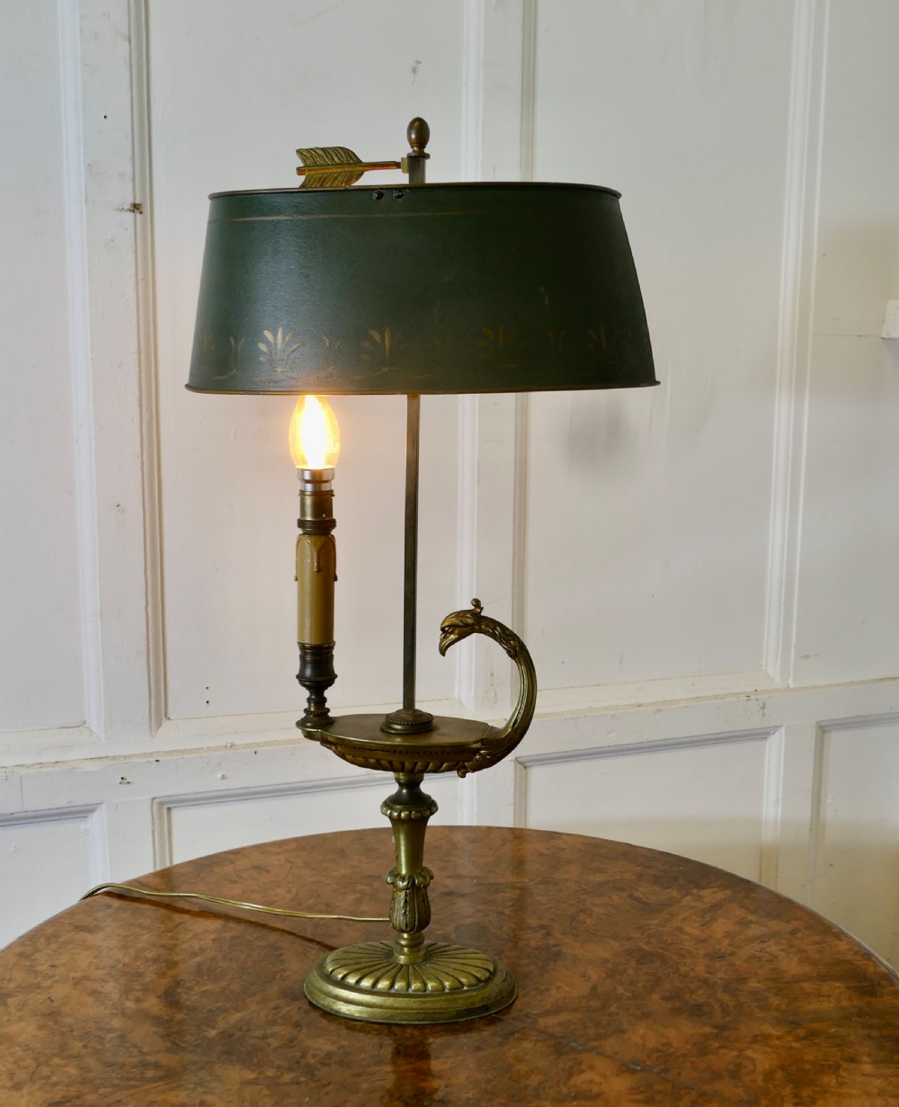 A French Neoclassical desk lamp featuring a dark green painted metal shade with gold stencilling mounted on a cast brass base with a swan-head neck motif.