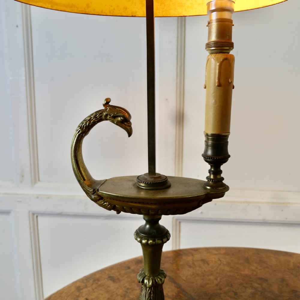 A French Neoclassical desk lamp featuring a dark green painted metal shade with gold stencilling mounted on a cast brass base with a swan-head neck motif. View X