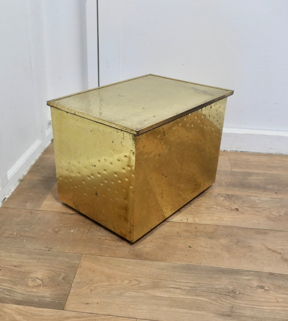 A rectangular Art Deco brass fireside log box featuring a hammered embossed surface texture and a flat hinged lid. View III