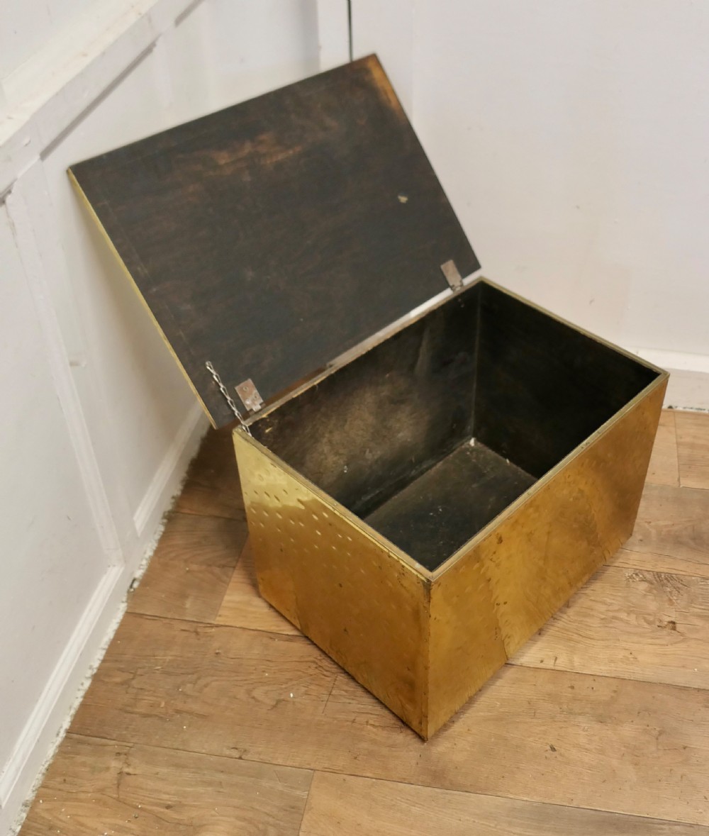 A rectangular Art Deco brass fireside log box featuring a hammered embossed surface texture and a flat hinged lid. View V