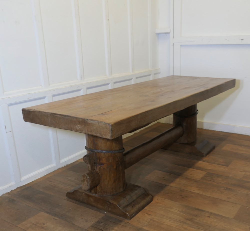A 19th-century French oak refectory table featuring a thick rectangular top supported by heavy cylindrical pedestal legs connected by a central stretcher. View II