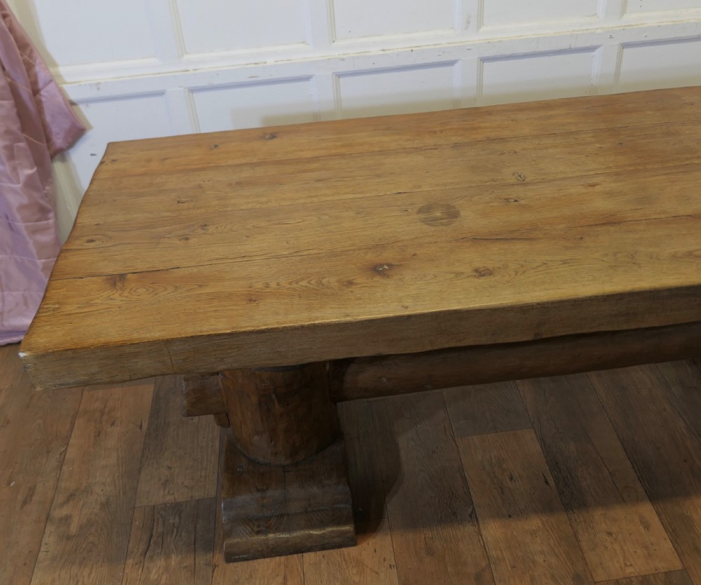 A 19th-century French oak refectory table featuring a thick rectangular top supported by heavy cylindrical pedestal legs connected by a central stretcher. View X
