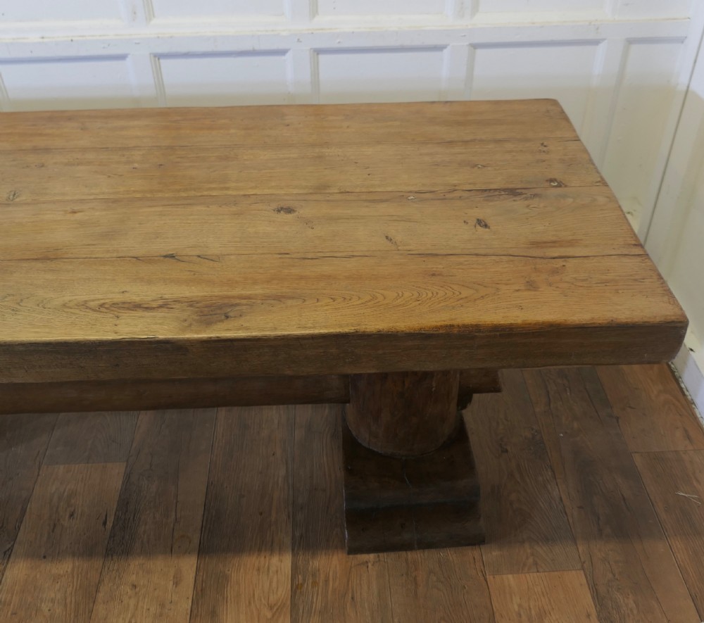 A 19th-century French oak refectory table featuring a thick rectangular top supported by heavy cylindrical pedestal legs connected by a central stretcher. View XI