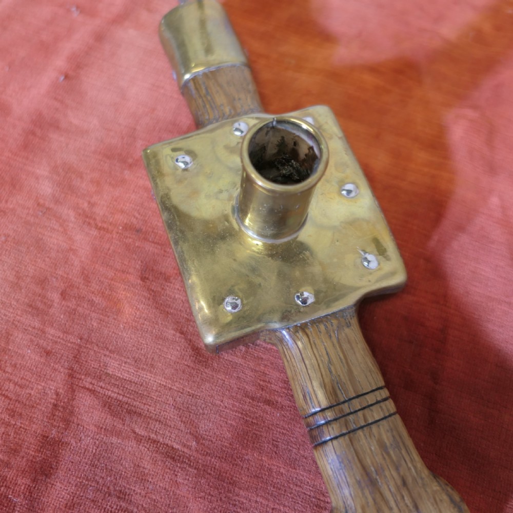 An antique French winery beam spike made from turned oak wood with a square brass socket plate and a long iron spike. View II