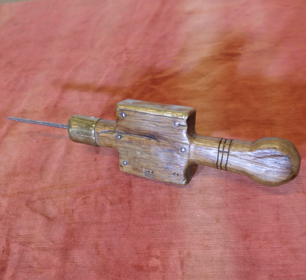 An antique French winery beam spike made from turned oak wood with a square brass socket plate and a long iron spike. View III