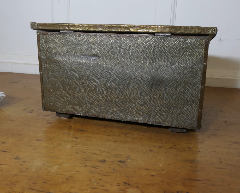 A hand-beaten brass slipper box featuring a sloped lid embossed with footwear imagery and decorative lettering reading Where they ought to be. View IV