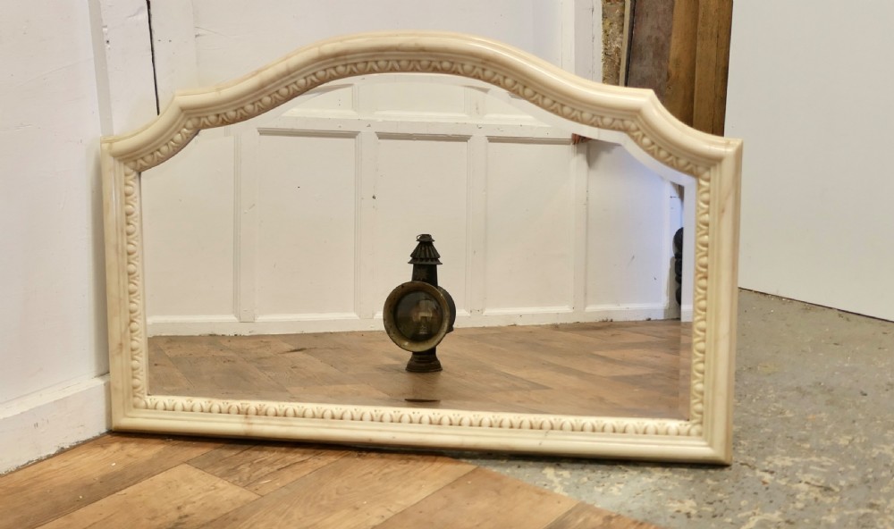 A large arched overmantel mirror featuring a cream simulated marble finish and carved egg-and-dart moulding along the interior rim. View II
