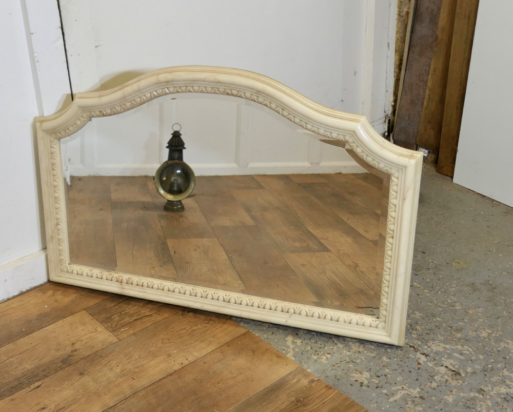 A large arched overmantel mirror featuring a cream simulated marble finish and carved egg-and-dart moulding along the interior rim. View V